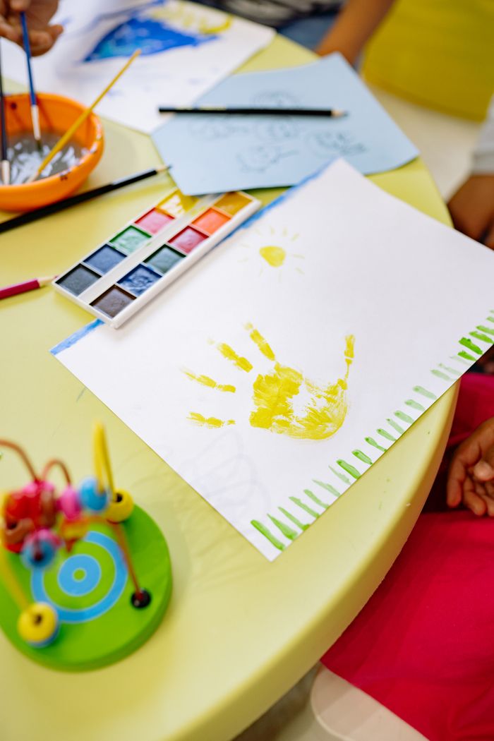 Top view of a preschool art table with watercolor painting and crafts. Creativity in action.
